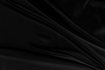 Black gray satin dark fabric texture luxurious shiny that is abstract silk cloth background with patterns soft waves blur beautiful.