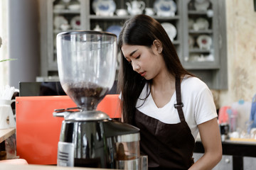 Asian women Barista using coffee machine in coffee shop counter - Working woman small business owner food and drink cafe concept.