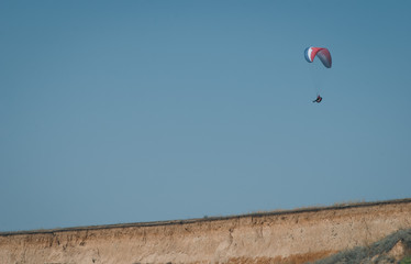Fototapeta na wymiar Paraglider against a clear sky. Jump off a cliff on a glider,