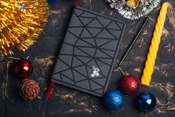 Black futuristic notebook at the Christmas table, the concept of creating a goal,
