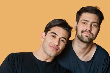 Portrait of young male friends over colored background