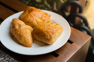 variety of bakery placed on a white plate on wooden table