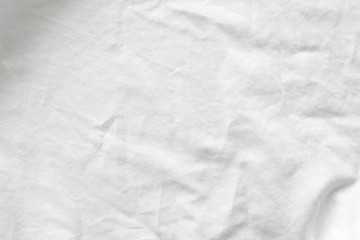 Close up shot of wrinkled white cotton shirt texture. Can see detail of the natural soft fabric. Crease Clothing textile or untidy bed sheet cover. Background wallpaper with copy space for edit