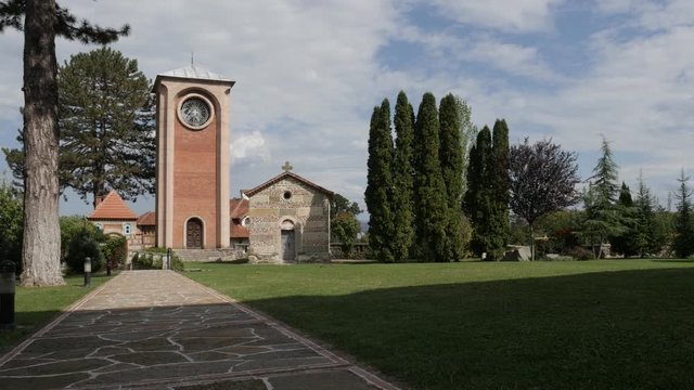 Garden with bell tower and other buildings of Zica monastery slow pan 4K video