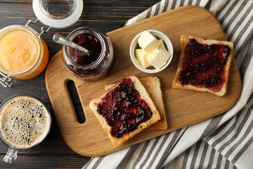 Composition with delicious toasts with jam on wood board, top view