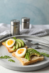 Toasts with avocado and egg, cutlery and towel on white background, space for text