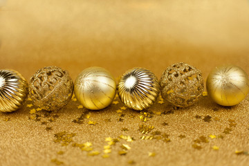 Christmas toys on a gold background. Christmas golden balls. Christmas motives. New Year.