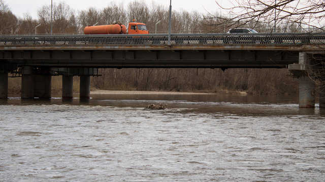 Bridge across Ulba river. Ust-Kamenogorsk (Kazakhstan). Traffic on the bridge. Grunge urban landscape.