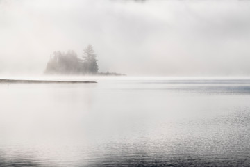 Cold morning fog over beautiful lake in autumn
