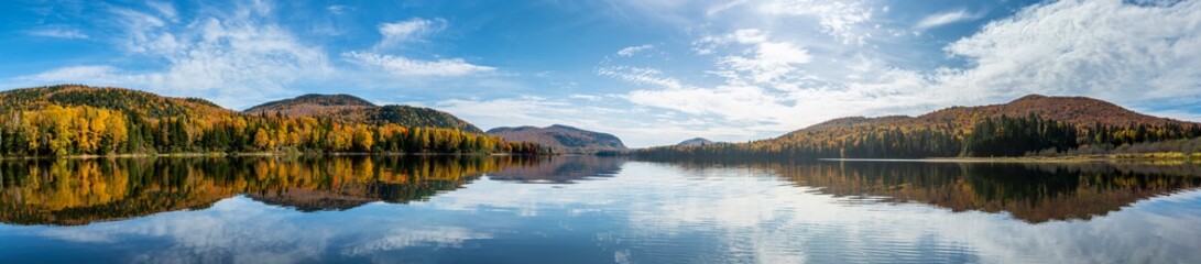 Panoramic View of beautiful autumn reflections in a national park lake.