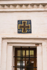 window in the wall with christian orthodox sign