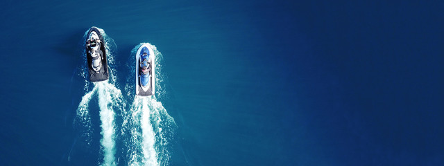 Aerial drone top view of jet skis cruising in deep blue sea