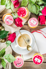 Valentine morning sweetheart scene. Breakfast on Valentine's Day February 14th. Sweet creative cupcakes with whipped cream and decor love, Valentine symbols. Mockup flatlay top view copy space