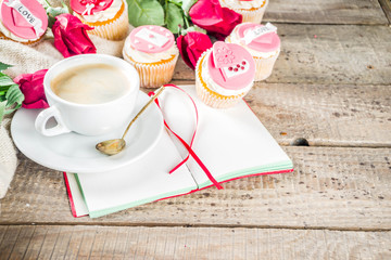 Valentine morning sweetheart scene. Breakfast on Valentine's Day February 14th. Sweet creative cupcakes with whipped cream and decor love, Valentine symbols. Mockup flatlay top view copy space