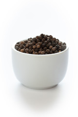 bunte pfefferkörner auf weißem grund zum würzen in der küche