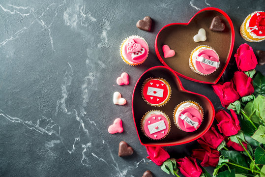 Valentine's day greeting card. Sweet Valentine's creative dessert food. Homemade pink and red delicious cupcakes with decor of Valentine day symbols