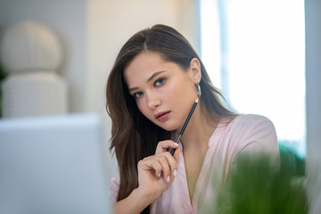Pretty nice young woman holding her pencil