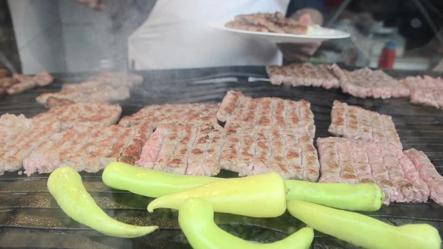 Cevapcici, cevapi on the grill. Balkans traditional food. Grilled dish of minced meat and vegetables. Grilled tasty meat on the barbecue. Preparing delicious food.