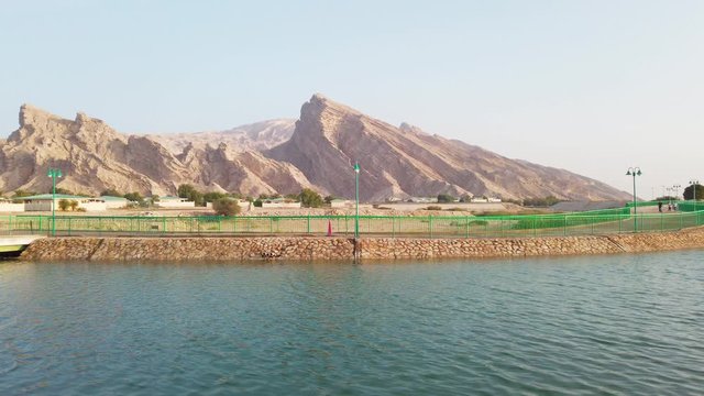 Jabal Hafeet mountain region in Tawam with a spring fountain, wide panning shot