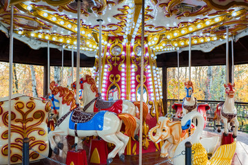 Fototapeta na wymiar Bright carousel horses in park close up