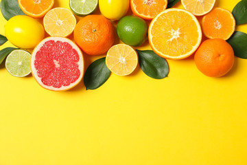 Juicy citrus fruits on yellow background, space for text
