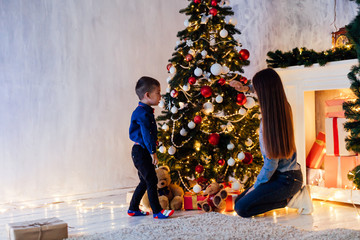 little boy with mom decorate the Christmas tree new year holiday