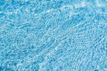 Fototapeta na wymiar In the summer, the sun shines and the background of water waves flickers. The texture of the water.