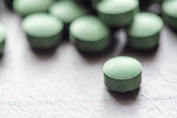 grüne Spirulina als Nahrungsergänzungsmittel auf grauem Grund © Kerstin