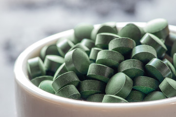 grüne Spirulina als Nahrungsergänzungsmittel auf grauem Grund © Kerstin