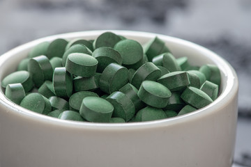 grüne Spirulina als Nahrungsergänzungsmittel auf grauem Grund © Kerstin