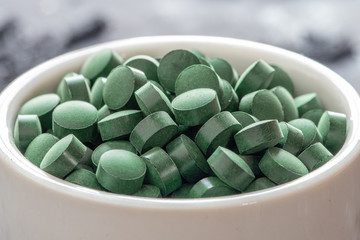 grüne Spirulina als Nahrungsergänzungsmittel auf grauem Grund © Kerstin