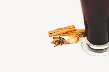 GLASS CUP OF COFFEE WITH CINNAMON ON WHITE BACKGROUND