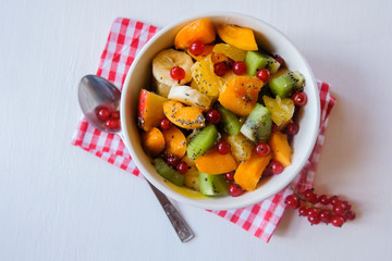 A bowl of fresh berry fruit salad on the white kitchen table. Vegan snack, diet food, healthy food concept.