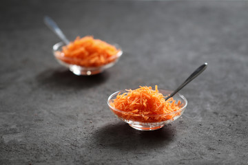 Still life with carrots on a dark background, vegetable salad with carrots, grated carrots