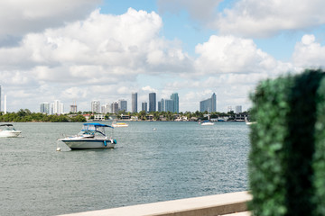Naklejka premium a boat travels through a harbor headed away from the city line of downtown Miami, Florida on a bright sunny morning