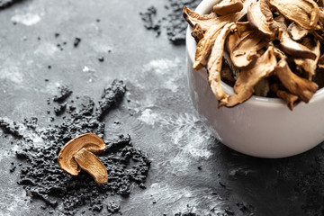 braune geschnittene gesammelte getrocknete Pilze auf grauem Grund im Herbst in einer weißen schale