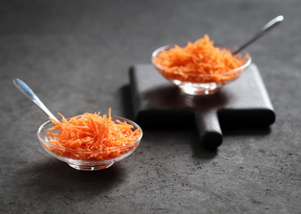 Still life with carrots on a dark background, vegetable salad with carrots, grated carrots