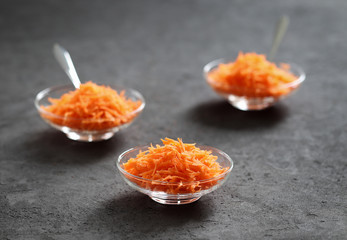 Still life with carrots on a dark background, vegetable salad with carrots, grated carrots