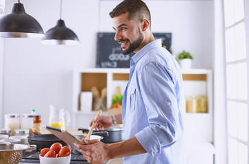Smiling and confident chef standing in large kitchen