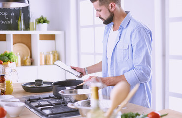 Smiling and confident chef standing in large kitchen