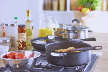Pasta rolled on fork over pan on stove in the kitchen