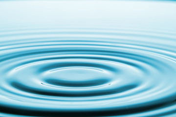 Closeup Water drop falling on the surface of the water and beautiful circular wave ripple, fresh natural mineral water drink water concept