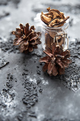 braune geschnittene gesammelte getrocknete Pilze auf grauem Grund im Herbst in einem Einmachglas