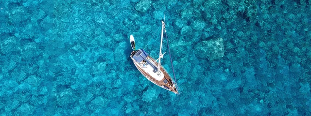 Poster Luchtfoto drone foto van luxe zeilboot aangemeerd in tropische exotische baai met turquoise kristalheldere zee © aerial-drone