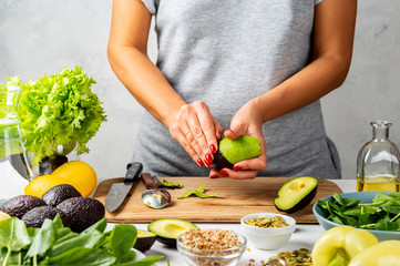 Woman peels avocado. cooking healthy food concept.
