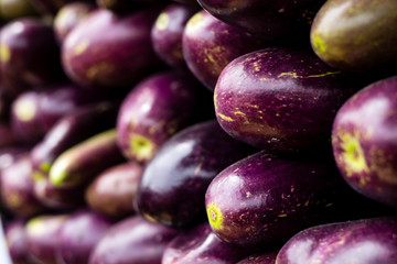 Closeup of organic purple end of eggplant (AKA aubergine or Guinea squash). Selected focus and filled frame, good for background use. Copy space. 