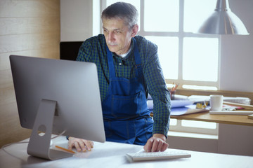 Fototapeta premium Engineer carpenter working on laptop and sketching project