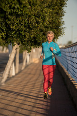 Female runner running down urban street, Alicante, Spain, Europe