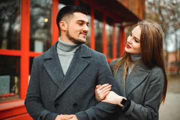 Loving couple in a coat walk along the street