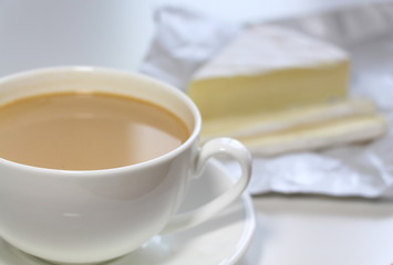 Coffee with milk. White cup. Soft brie cheese. Morning. Tasty breakfast.